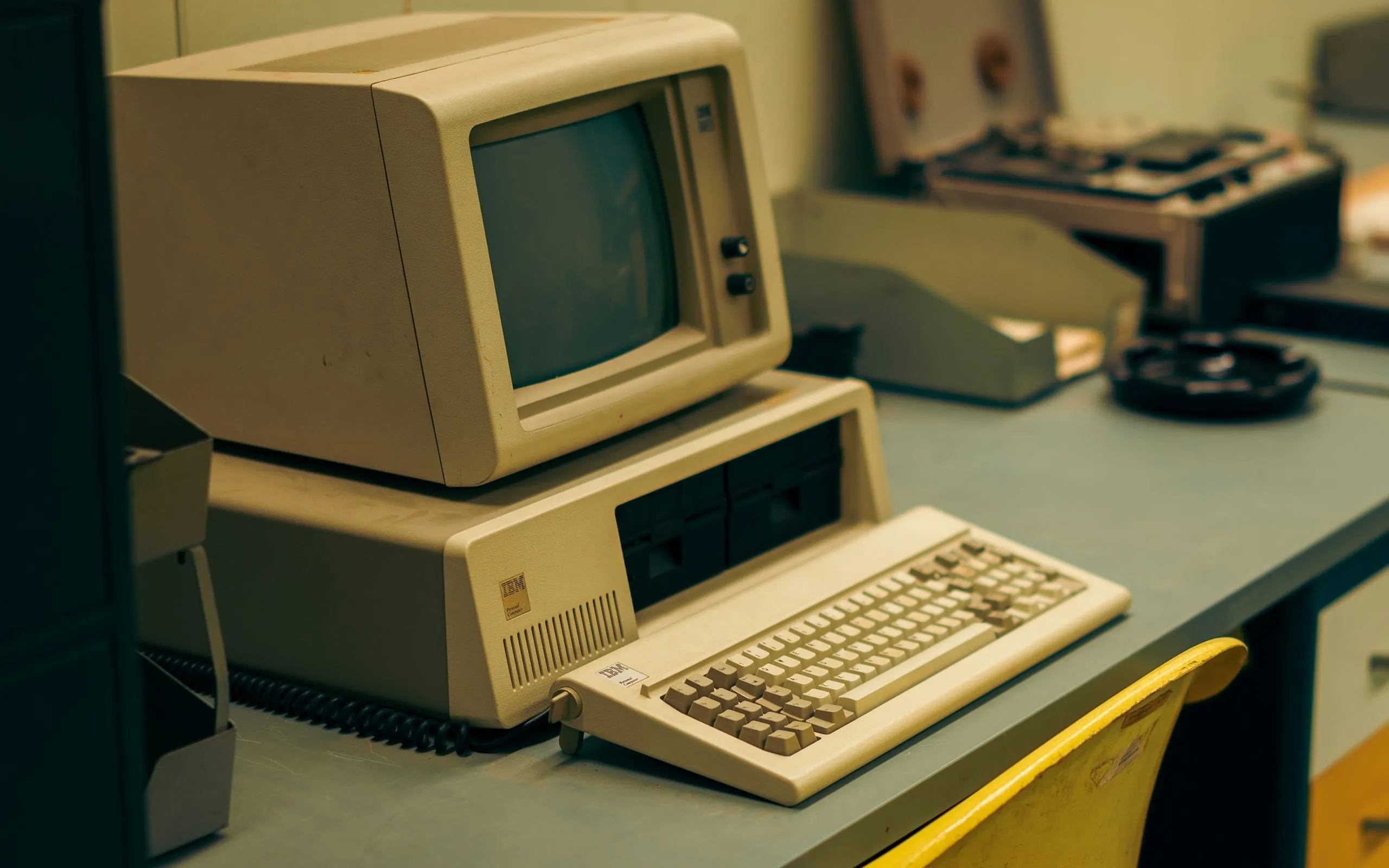 Un vieil ordinateur beige posé sur un bureau, témoin d’une technologie dépassée